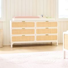 a baby's crib and dresser in a white room