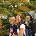 a woman and two children are posing for a photo in front of some trees with their backpacks on