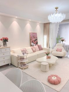 a living room filled with white furniture and pink accents