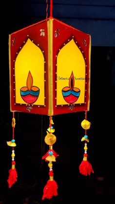 a red and yellow lantern with tassels hanging from it's sides in the dark