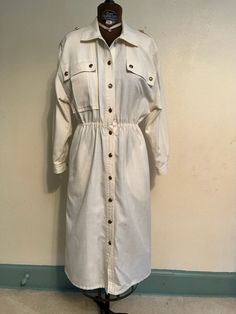 "Vintage 1980's white dress.  'Little g' brand from Brainerd, Minn. Has elastic waist and front pockets.  Padded shoulders and decorative buttons.  Two small spots. Measurements: Bust: 17\" Waist: 26\" stretches to 38\" Sleeve: 19\" Waist to hem: 26\"" Classic White Shirt Dress For Fall, White Button-up Shirt Dress With Pockets, White Button Shirt Dress For Fall, White Long Sleeve Shirt Dress With Button Closure, White Button Closure Shirt Dress For Fall, Vintage Button-up Shirt Dress, Vintage Long Sleeve Shirt Dress For Work, Front Button Dress, Brainerd Minnesota