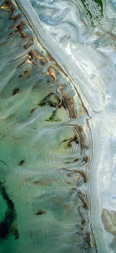 an aerial view of the water and land in this photo, looking down at it