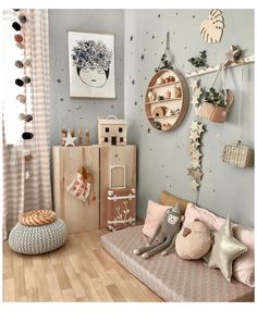 a child's bedroom decorated in pastel colors with toys and decorations on the wall