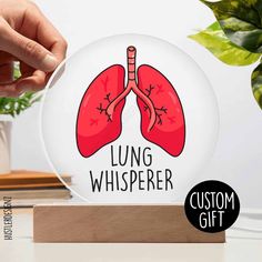 the lung whisperer glass ornament is shown on top of a wooden stand