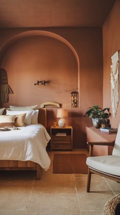 a bedroom with a bed, chair and other items on the table in front of it