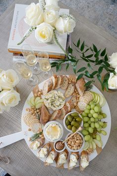 a platter filled with cheese, crackers and grapes