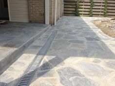 a driveway with steps leading up to a garage door and side walk in front of it