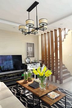 a living room filled with furniture and a flat screen tv on top of a wooden table