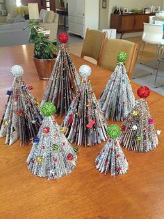 several christmas trees made out of magazines on a table