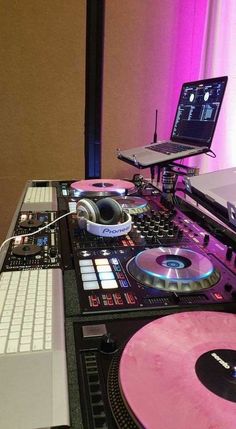 a dj's turntable with two laptops on it and a keyboard in front of them