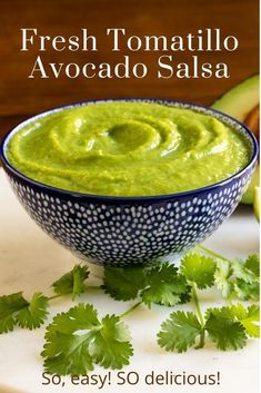 an avocado dip in a blue and white bowl with cilantro on the side