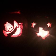 two pumpkins with faces carved into them in the dark, one has stars on it