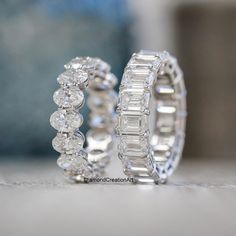 two diamond wedding rings sitting next to each other