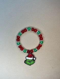 Adorable Grinch Bracelet - Perfect for Christmas and the Holidays! This charming bracelet features stunning red and green beads complemented by silver spacers. Christmas Holiday Beaded Bracelets With Colorful Beads, Christmas Beaded Stretch Bracelet Gift, Christmas Holiday Green Jewelry, Festive Green Beaded Bracelets With Colorful Beads, Multicolor Beaded Bracelets For Christmas Holiday, Green Christmas Holiday Jewelry, Festive Green Beaded Bracelets, Adjustable Beaded Stretch Bracelet For Christmas, Christmas Gift Bracelets With Colorful Beads