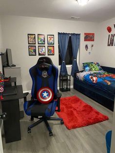 a room with a bed, desk and chair in it that has captain america decorations on the walls