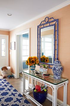 a blue and white vase sitting on top of a glass table next to a mirror