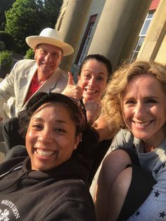 three women and one man are smiling for the camera