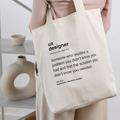 a woman carrying a tote bag with the words ux designer on it