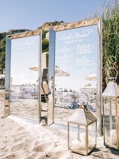 three mirrored mirrors on the beach with candles in front of them