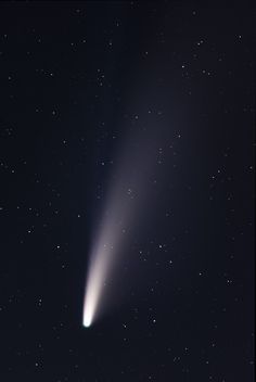 an image of a comet in the sky with stars around it and one light emitting from its tail