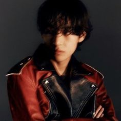 a young man wearing a red leather jacket