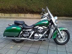 a green motorcycle is parked on the street