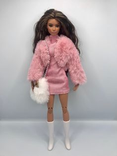 a barbie doll wearing a pink dress and fur coat holding a white purse in her hand