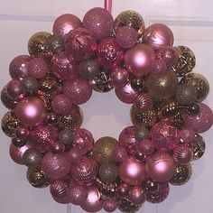 a pink and gold christmas ornament wreath