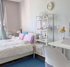 a bedroom with a bed, desk and computer on the wall in front of a window