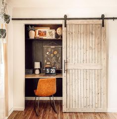 a room with wooden floors and a sliding door that leads to a desk in the corner