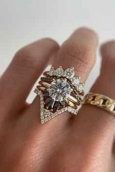 a woman's hand with two rings on it and one ring has a diamond in the middle