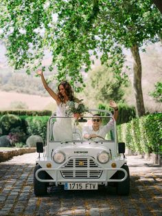 a bride and groom riding in the back of a white jeep