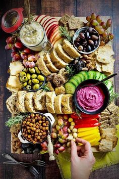 a platter filled with bread, olives, crackers and other food items