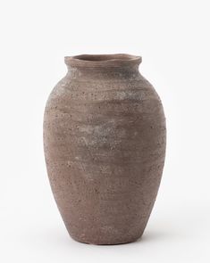 a gray vase sitting on top of a white table