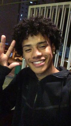 a young man making the peace sign with his fingers