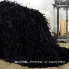 a large black feather pillow on the floor next to a candle