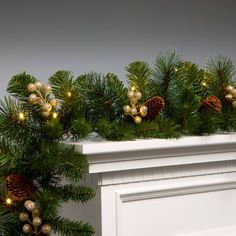 christmas garland with pine cones and lights on fireplace mantel