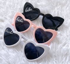 three heart shaped sunglasses with the word bake written on them, sitting on a white furnishing