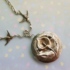 an antique locke with two birds hanging from it's side on a necklace chain