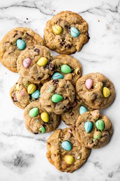 chocolate chip cookies with candy eggs and m & m's in the middle on a marble surface