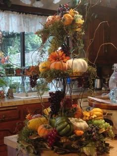 an arrangement of fruits and vegetables on a kitchen counter top in front of a window