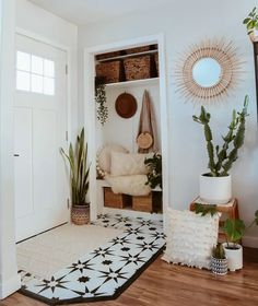 an entryway with plants and baskets on the wall, potted cacti