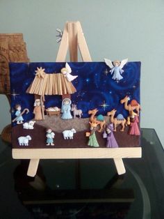 a nativity scene is displayed on top of a wooden easel in front of a blue background