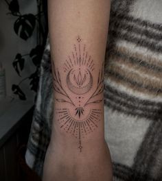 a woman's arm with a tattoo design on the left side of her arm