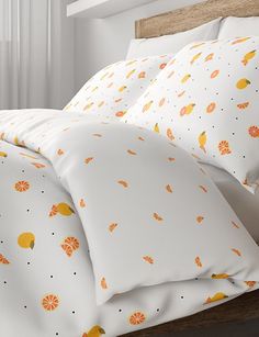 a bed with white sheets and oranges on it