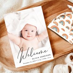 a baby's birth announcement is displayed on a wooden tray