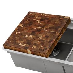 a wooden cutting board sitting in the middle of a sink