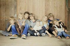 a group of people sitting next to each other in front of a wooden wall and door