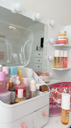 a white vanity with lots of beauty products on it's drawers and shelving in the background