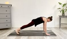 a woman is doing a yoga pose on a mat in a room with white walls